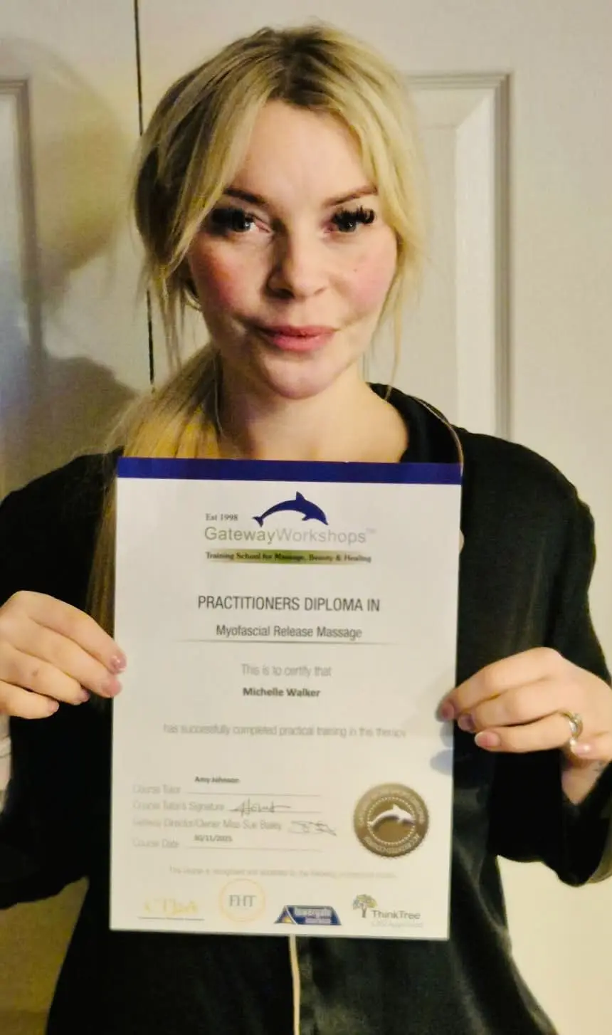 Michelle Walker holding her practitioner diploma in myofascial release massage
